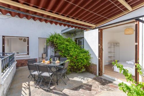 un patio extérieur avec une table et des chaises dans l'établissement Le Pré Vert - Terrasse - Calme - Netflix, au Mans