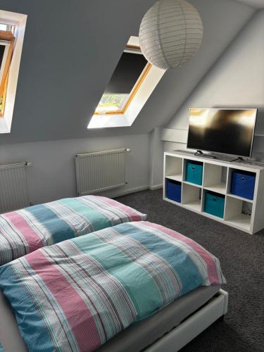 a bedroom with a bed and a flat screen tv at Ferienhaus am Friedenshain in Oderberg