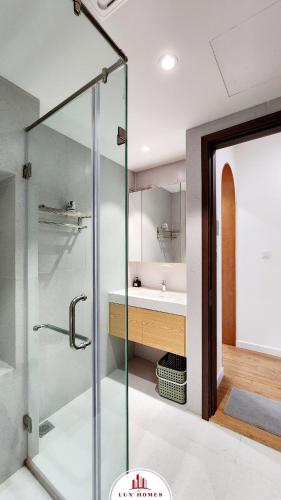 a glass shower in a bathroom with a sink at The LuxHomes Apartment ᵀᴹ I HOT Độc Đáo Nhất Vinhomes Marina in Hai Phong