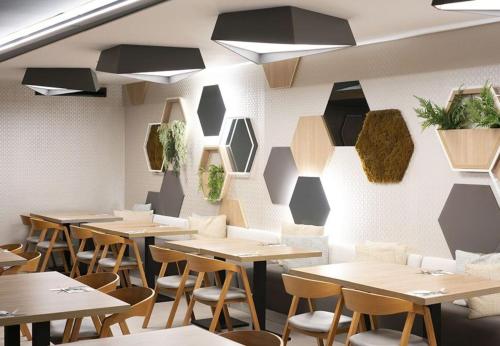 a restaurant with tables and chairs and plants on the wall at MYND Adeje in Adeje