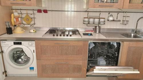 a kitchen with a stove and a washing machine at Coral & Turquoise in Pozzuoli