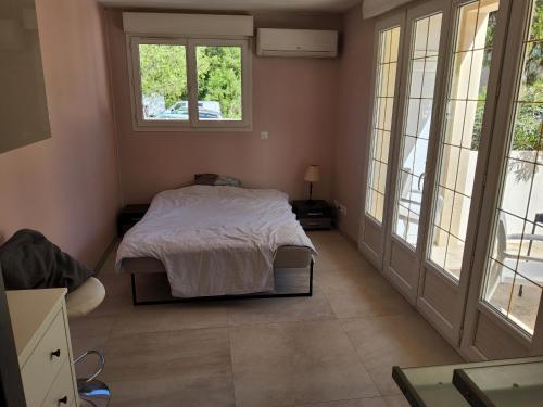 une chambre avec un lit dans une pièce avec des fenêtres dans l'établissement Villa avec piscine privative, à Solliès-Toucas