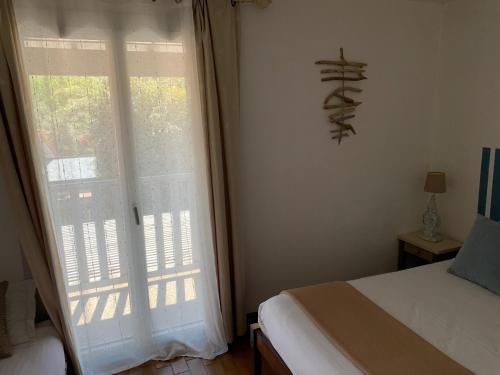 a bedroom with a bed and a large window at LOGIS HOTELS - Hôtel et Restaurant L'Océana in Lanton