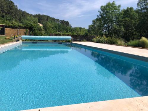 une piscine avec de l'eau bleue dans une cour dans l'établissement La Magnanerie de l'Estrade, gîte 8 pers avec piscine, à Rosières