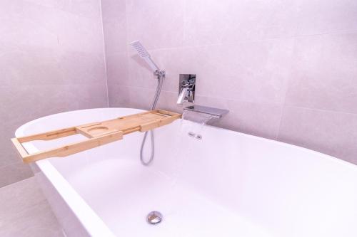 a bathroom with a bath tub with a shower at Eden House and Pet Farm in Feevaghmore