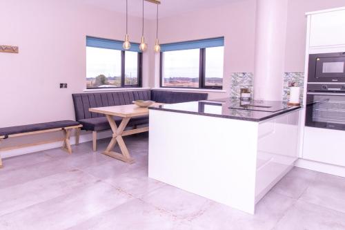 a kitchen and dining room with a table and a couch at Eden House and Pet Farm in Feevaghmore