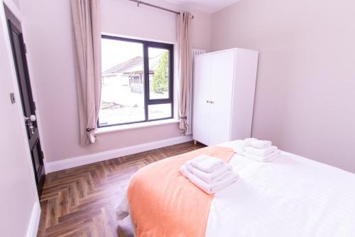 a bedroom with a bed with towels on it at Eden House and Pet Farm in Feevaghmore
