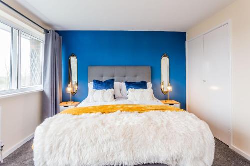 a bedroom with a large bed with a blue wall at Prebends Field in Gilesgate