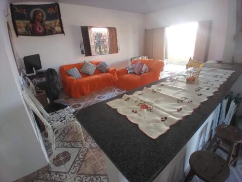 a living room with a large table with an orange couch at Aguiar beach house in Salinópolis