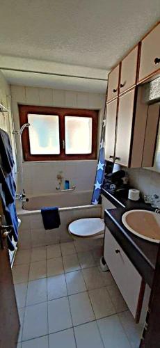 a bathroom with a tub and a toilet and a sink at FREE cable car & bus in the summer Haus L'oree in Saas-Grund