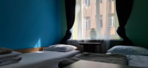 two beds in a room with a window at Jamaika @ Shopen in Vilnius