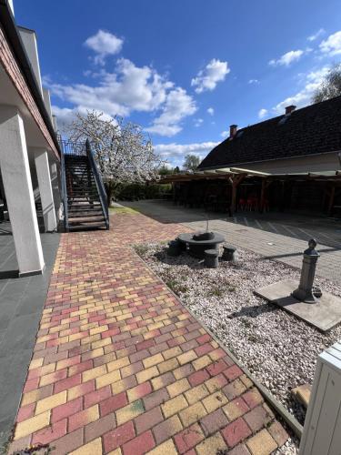 a brick walkway in a yard next to a house at Sulyom Panzió in Tiszafüred