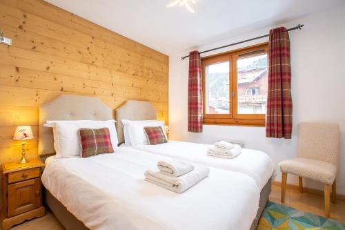 une chambre avec un grand lit blanc avec des serviettes dessus dans l'établissement Hidden 2 bed gem in prime central location, à Morzine