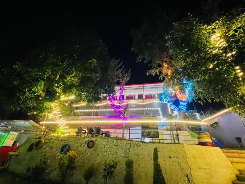 a building with lights in front of it at night at Ananta Ganges Rishikesh Camping in Shivpuri