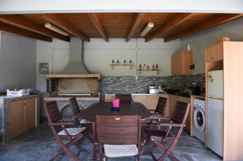 a kitchen with a table and chairs in it at Nonta's Garden - nature & waves in Yiannitsokhórion