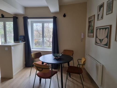 une salle à manger avec une table et des chaises et une fenêtre dans l'établissement La maison du quai, à LʼIsle-sur-la-Sorgue
