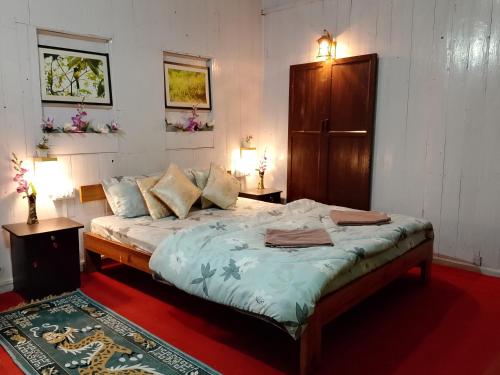 a bedroom with a bed with two tables and two lamps at Maliani Farms in Takdāh