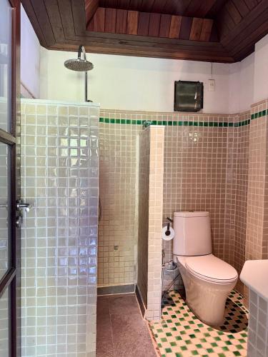 a bathroom with a toilet and a glass shower at Glass Cottage in Wok Tum