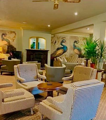 a lobby with chairs and a table and a fireplace at Moffat House in Moffat