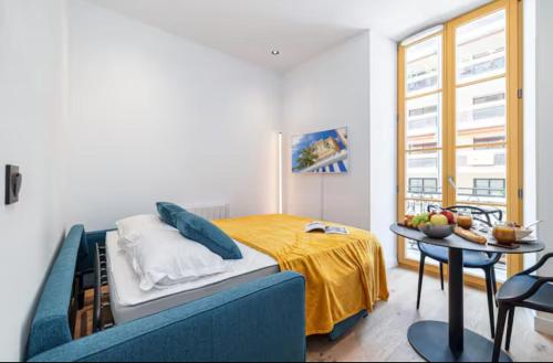 une chambre avec un lit et une table dedans dans l'établissement Cozy studio near the sea, à Nice