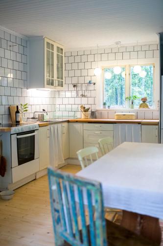 a kitchen with a table and chairs in it at Swedish cottage in the Woods on Sollerön island in Sollerön