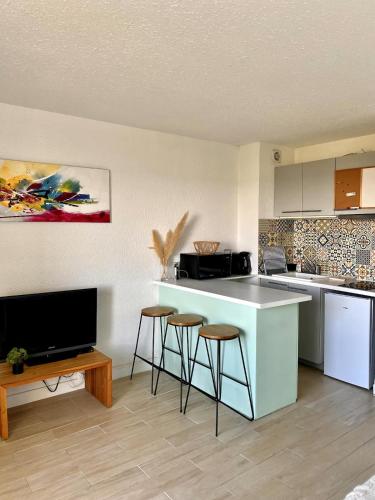 une cuisine avec un comptoir et des tabourets dans une pièce dans l'établissement Studio Carnon proche plage et port, à Mauguio