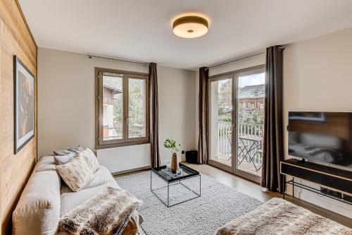 un salon avec un canapé et une télévision dans l'établissement White Pearl Mountains, à Chamonix-Mont-Blanc