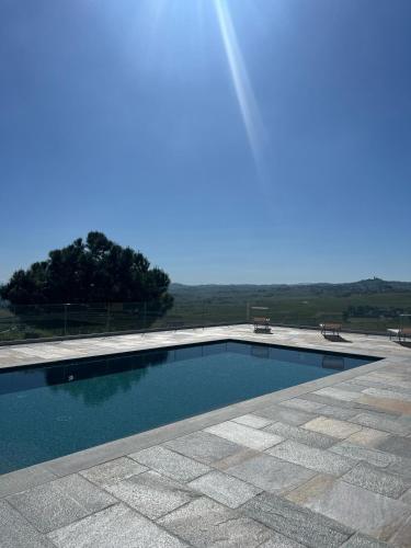 a swimming pool with two benches sitting around it at Dimora Relax in Costigliole dʼAsti