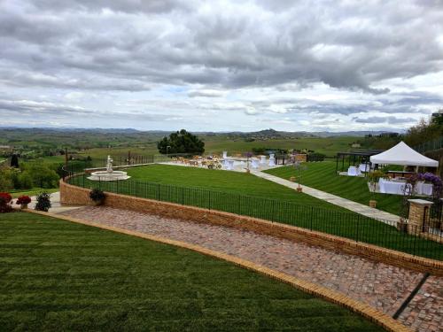 a view of a lawn with a fence and a tent at Dimora Relax in Costigliole dʼAsti