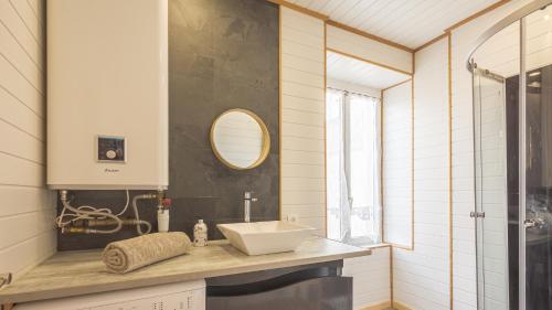 une salle de bain avec un lavabo et un miroir dans l'établissement Les Suites du Jardin 3 - Instant vole - Hypercentre, à Chaumont