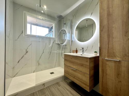 une salle de bain avec une douche, un lavabo et un miroir dans l'établissement Magnifique appartement 3 pièces avec double vue mer, à Ajaccio