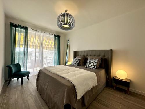 une chambre avec un lit, une chaise et une lampe dans l'établissement Magnifique appartement 3 pièces avec double vue mer, à Ajaccio