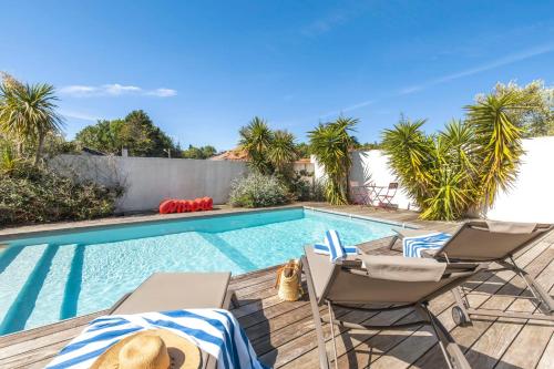 une piscine avec deux chaises longues et une piscine dans l'établissement Amore - High standing contemporay villa, à Biarritz