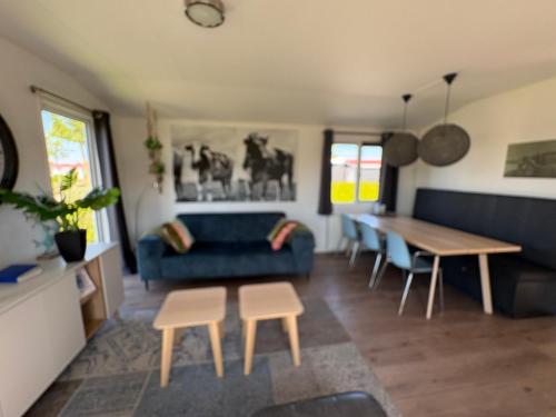 a living room with a blue couch and a table at Olmenduin | Chalet 26 | Zeeland in Serooskerke