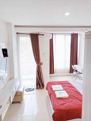a bedroom with a red bed and a desk at Rouyame room by greenpark apartment in Seturan
