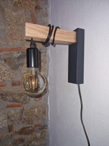 a light hanging on a wall with a wall at Su Furriadroxiu in San Vito