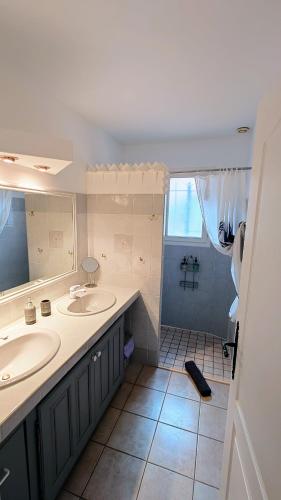 une salle de bain avec deux lavabos et une douche dans l'établissement Villa Floralys, à Llauro