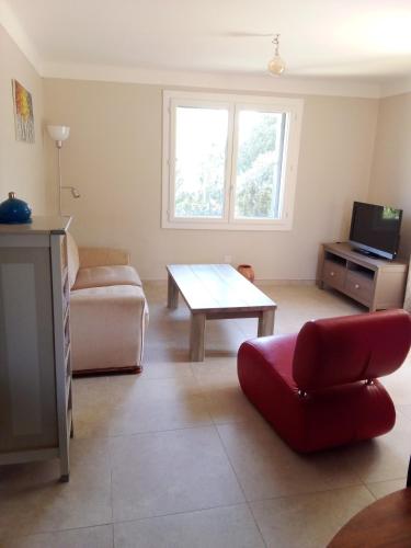 un salon avec un canapé rouge et une table dans l'établissement charmant logis avec vue sur l'Hérault pour 4 personnes à Aniane, à Aniane