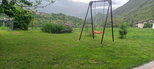 a swing set in a grassy yard with mountains in the background at Maison Lella in Pontey