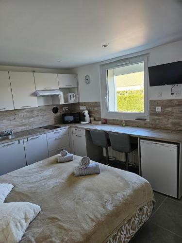- une cuisine avec un grand lit et des serviettes dans l'établissement La petite bulle d'Aurel, à Quesques