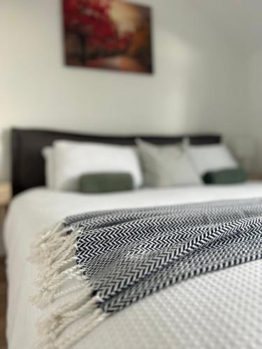 a bed with a black and white comforter on it at Boutique Townhouses Letterfrack Village - Entrance to Connemara National Park in Letterfrack