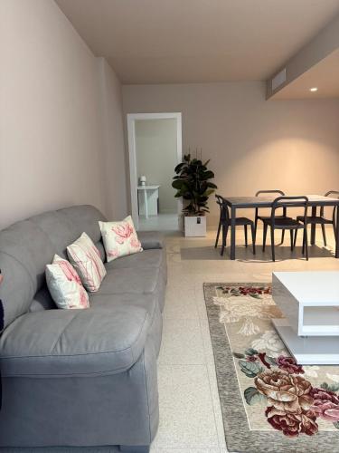 a living room with a gray couch and a table at Ca' Monte - Dimora Centrale con 3 camere da letto in Montebelluna