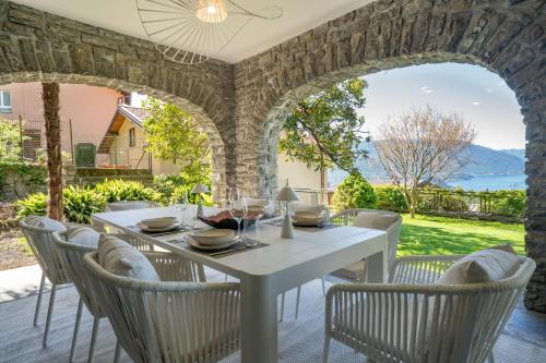 a dining room with a white table and chairs at Casa di Lou - Panoramic villa in Perledo in Perledo