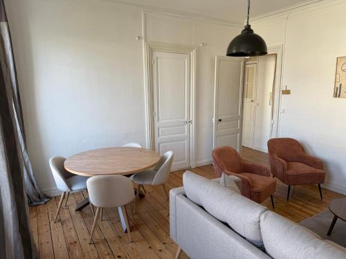 a living room with a table and a couch at L'authentique - Hyper centre et Gare in Saint-Brieuc