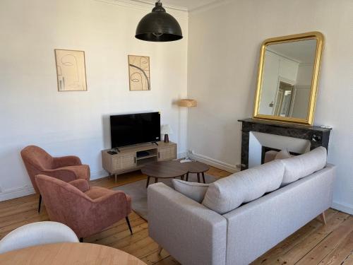 a living room with a couch and a mirror at L'authentique - Hyper centre et Gare in Saint-Brieuc