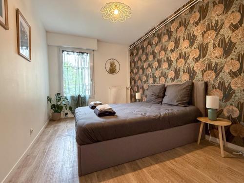 - une chambre avec un lit orné d'un mur fleuri dans l'établissement T3 modern avec parking et balcon, à Chartres