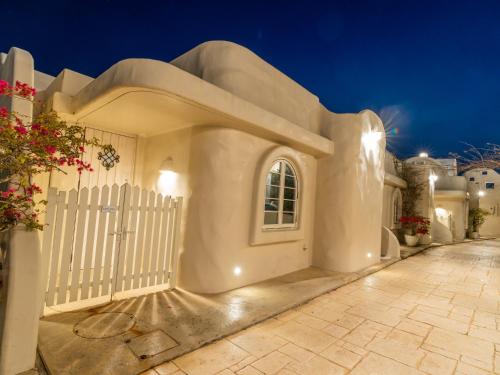 a white house with a white gate at night at Yuki Suite Kourijima in Nakijin