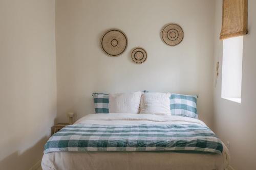 a bed in a bedroom with two hats on the wall at Gîte Guillaumand in Pompignan