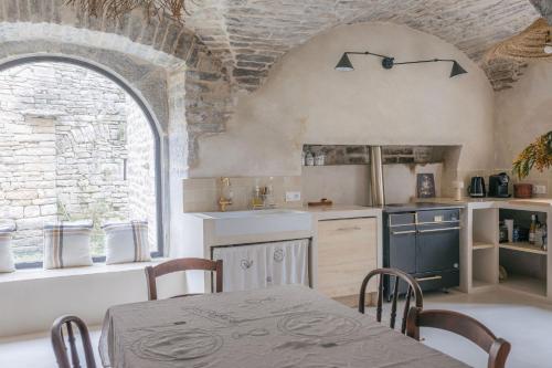 a kitchen with a table and a sink and a window at Gîte Guillaumand in Pompignan