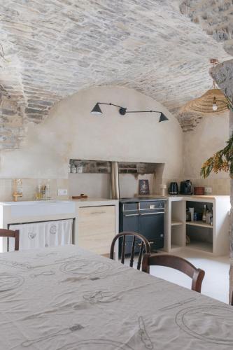 a kitchen with a table with chairs and a ceiling at Gîte Guillaumand in Pompignan